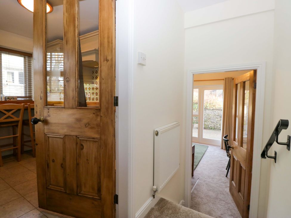 A hallway with a door and staircase at 11 Tram Lane Kirkby Lonsdale