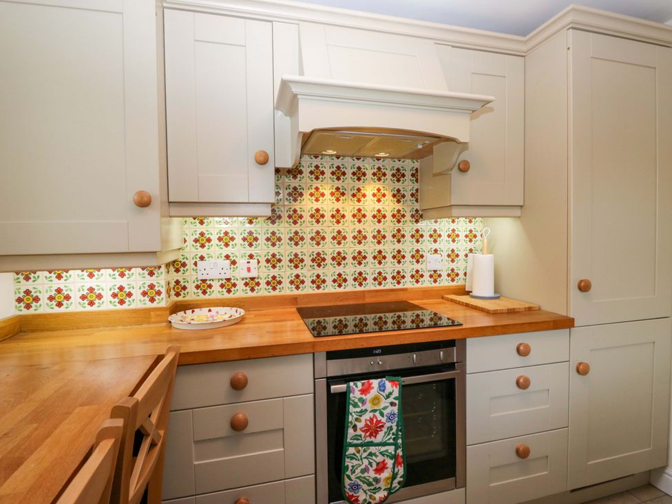 A kitchen with cabinets and cooktop at 11 Tram Lane in Kirkby Lonsdale