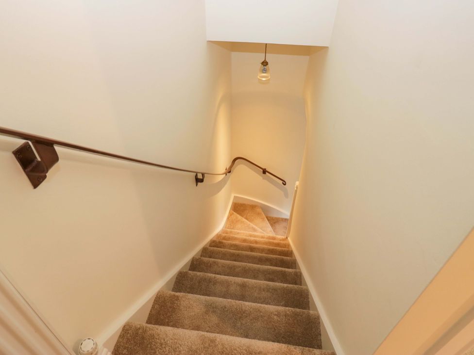 A staircase with a handrail and lighting at 11 Tram Lane Kirkby Lonsdale