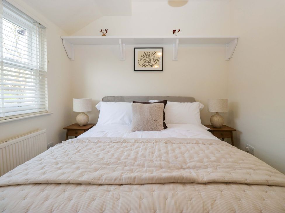 A bedroom with a bed and lamps at 11 Tram Lane in Kirkby Lonsdale