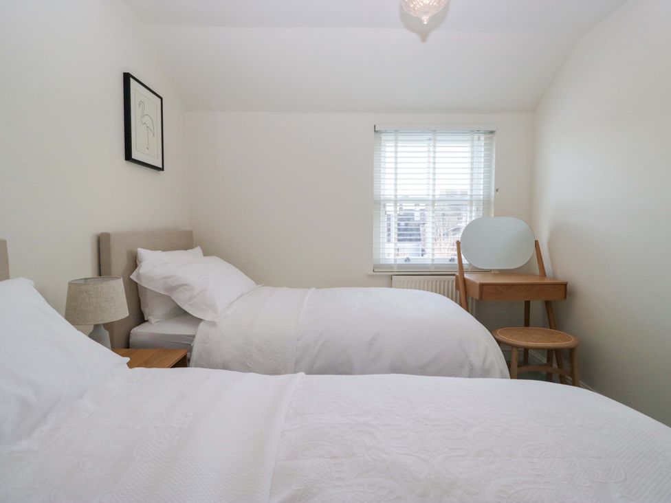 A bedroom with two beds and a dressing table at 11 Tram Lane Kirkby Lonsdale