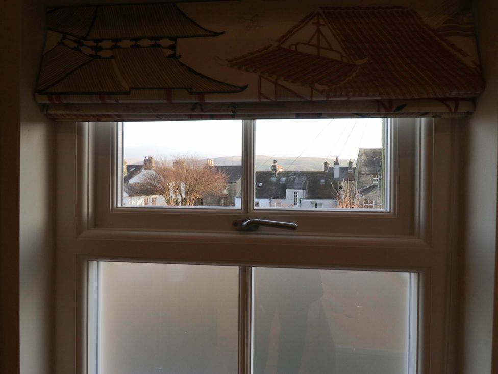 A window with a view of houses and a tree at 11 Tram Lane in Kirkby Lonsdale