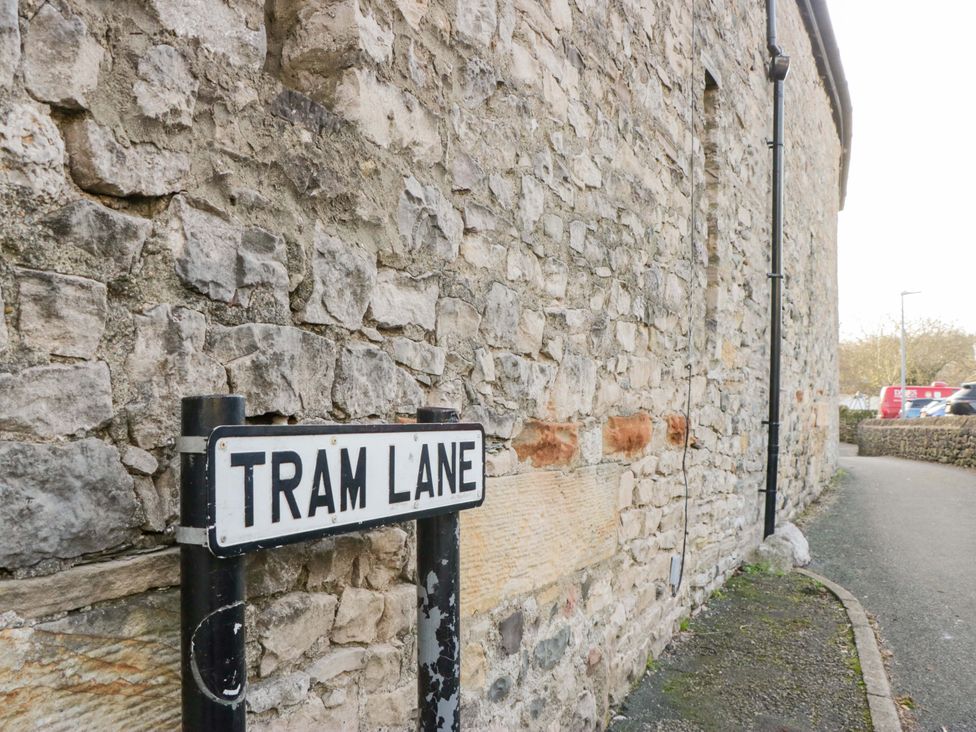A street sign for Tram Lane next to a stone wall at 11 Tram Lane Kirkby Lonsdale