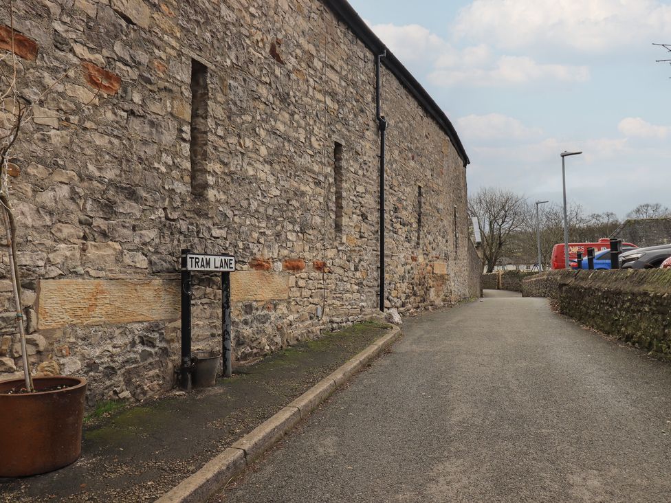 A stone wall with a sign for Tram Lane in Kirkby Lonsdale