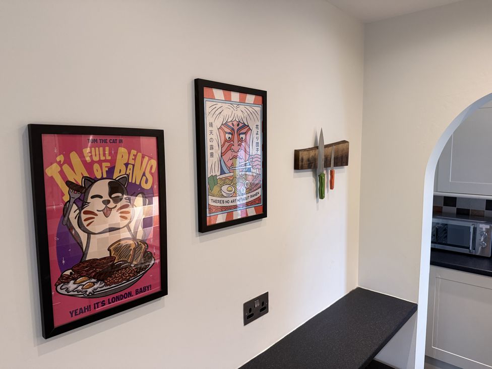 A kitchen with framed artwork and a knife holder at New House Barn Ashbourne