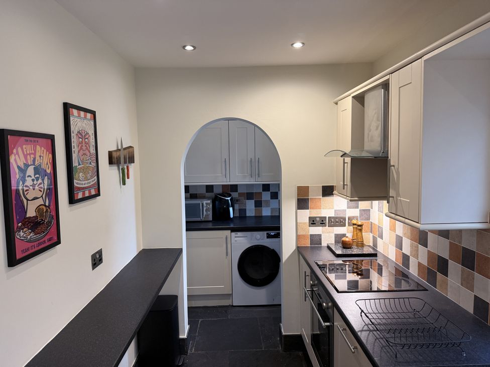 A kitchen with appliances and art on the wall at New House Barn Ashbourne