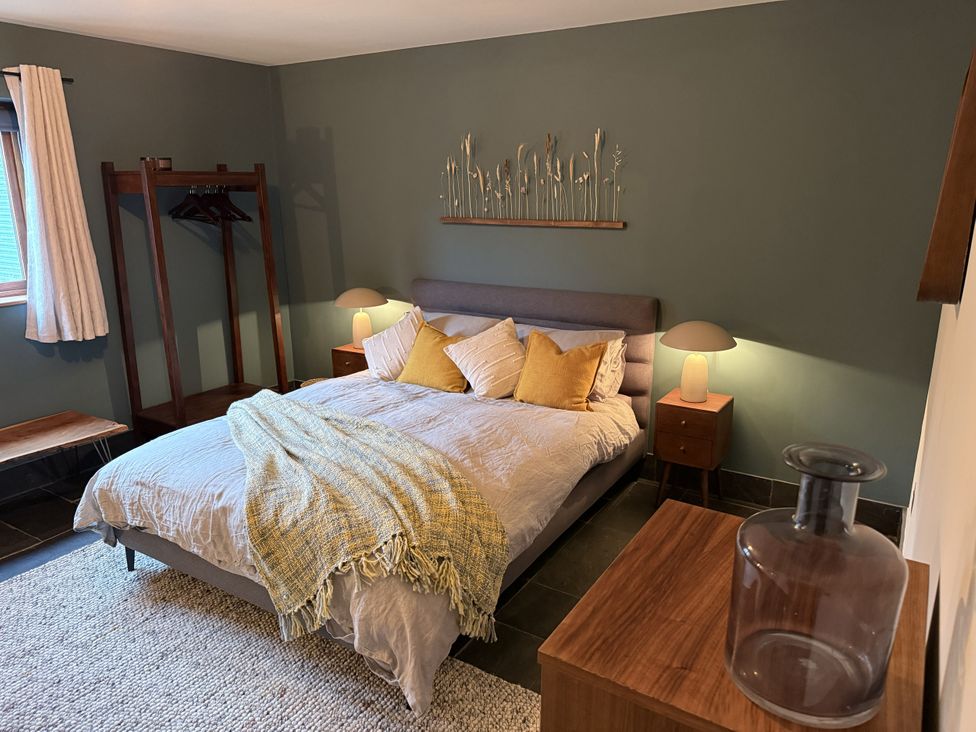 A bedroom with a bed, nightstands, and wardrobe at New House Barn Ashbourne