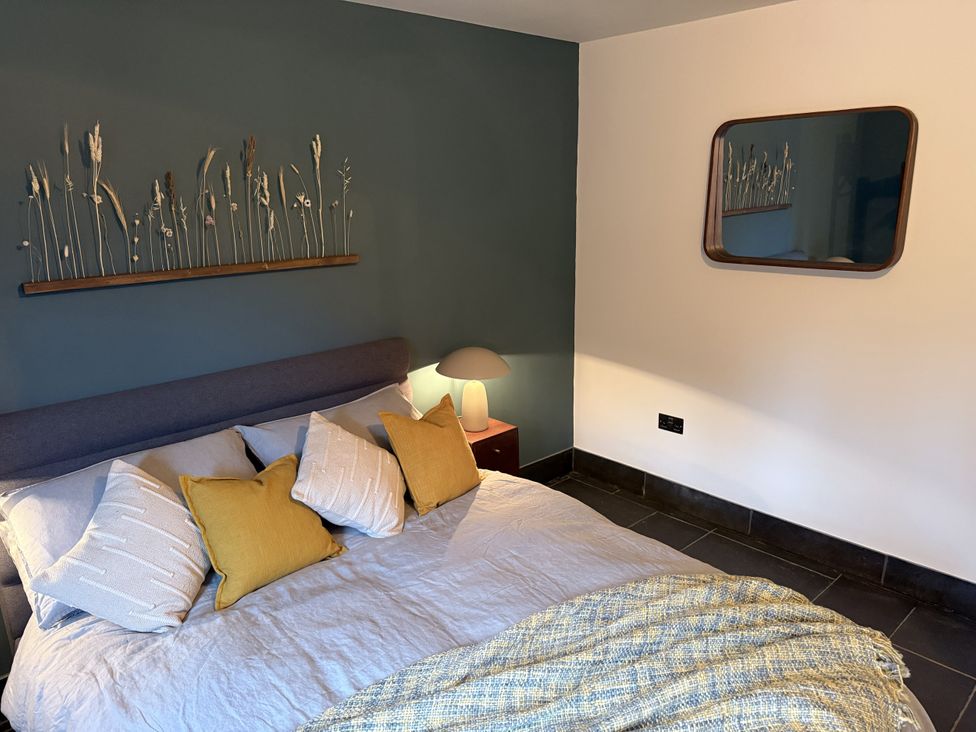 A bedroom with a bed and bedside table at New House Barn in Ashbourne