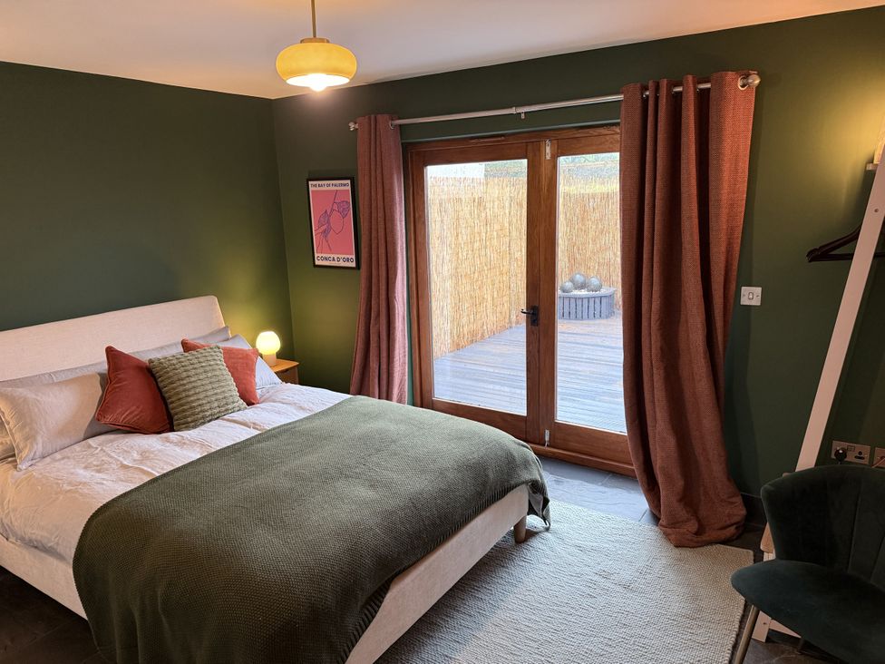 A bedroom with a bed and a door leading outside at New House Barn Ashbourne