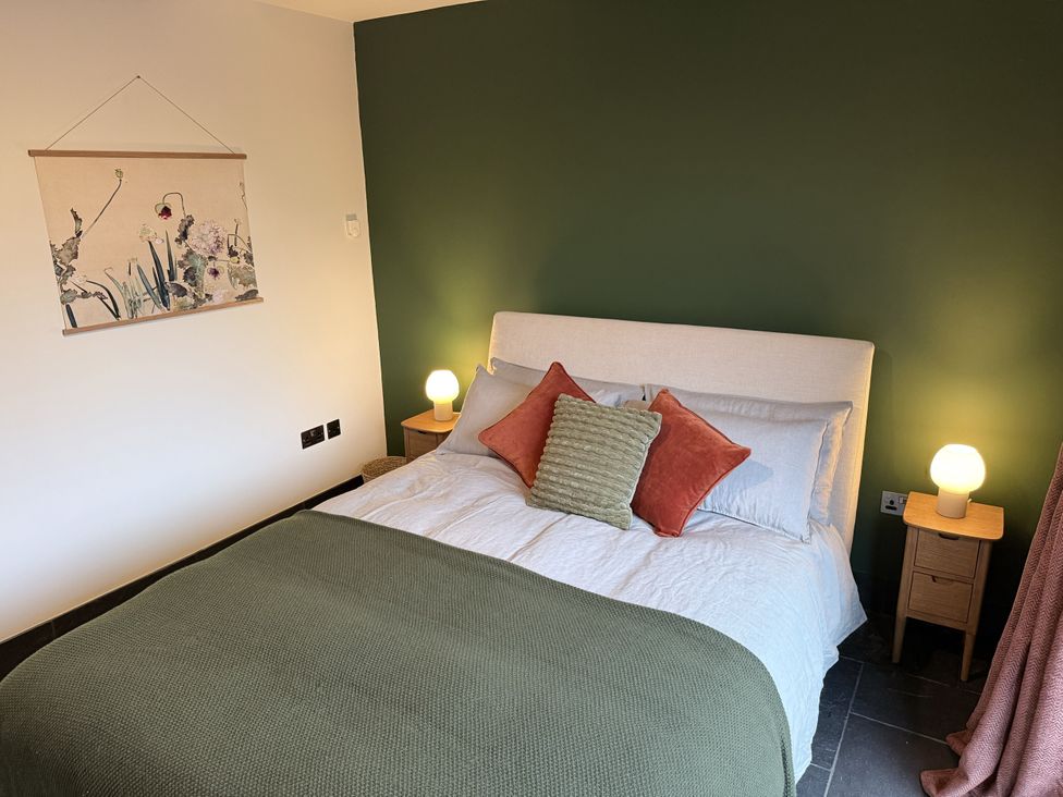 A bedroom with a bed and wall art at New House Barn in Ashbourne