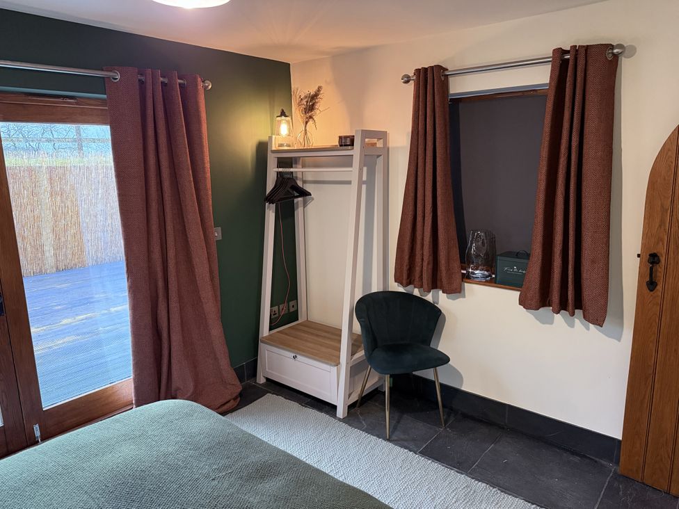 A bedroom with a bed and a clothes rack at New House Barn in Ashbourne