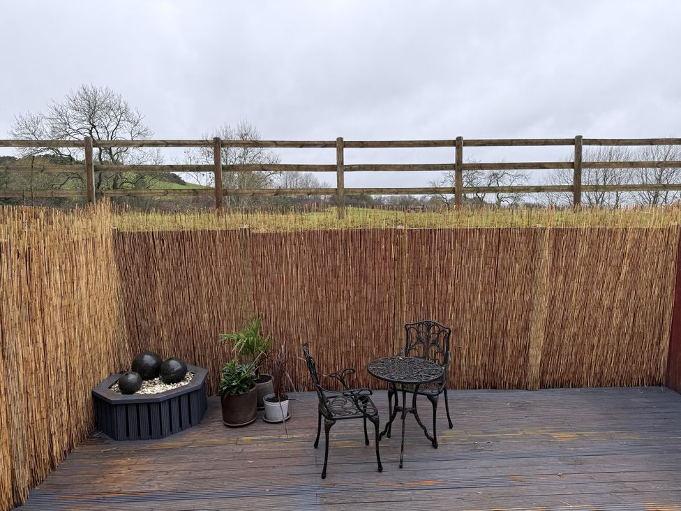 A patio with a table, chairs and a planter at New House Barn Ashbourne