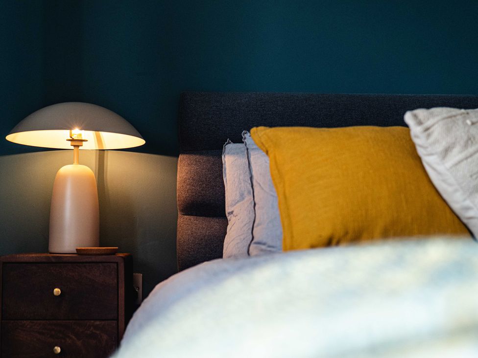 A bedroom with a bed and a bedside lamp at New House Barn in Bradley near Ashbourne