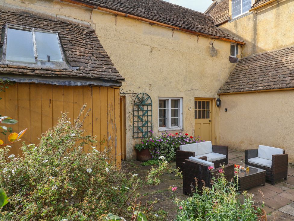 A garden with seating area and flowers at The Old Dairy Acton Turville near Nettleton