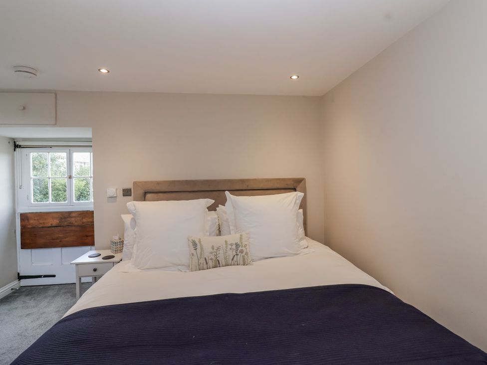 A bedroom with a bed and window at The Old Dairy in Acton Turville near Nettleton