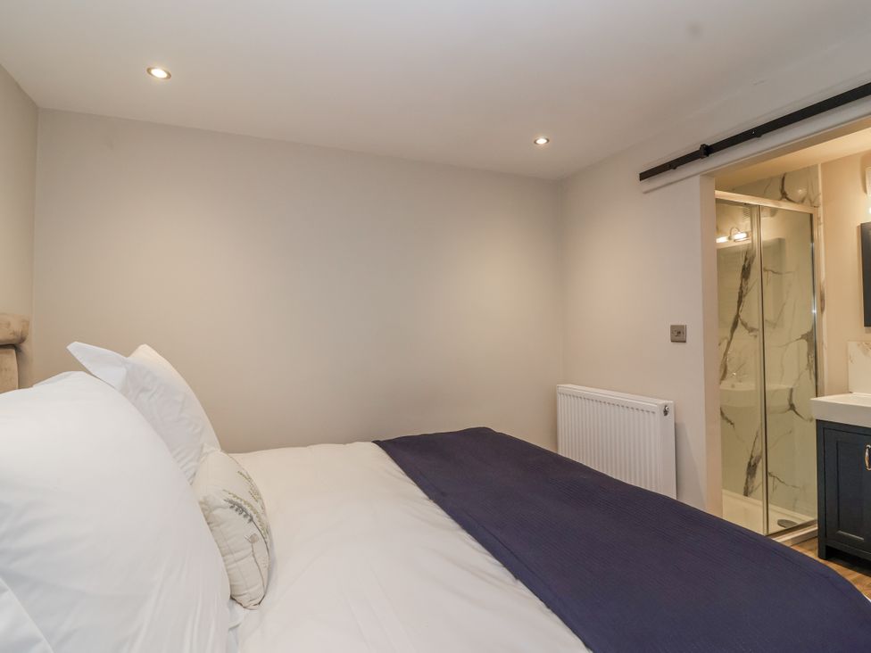 A bedroom with a bed and connected shower area at The Old Dairy near Nettleton