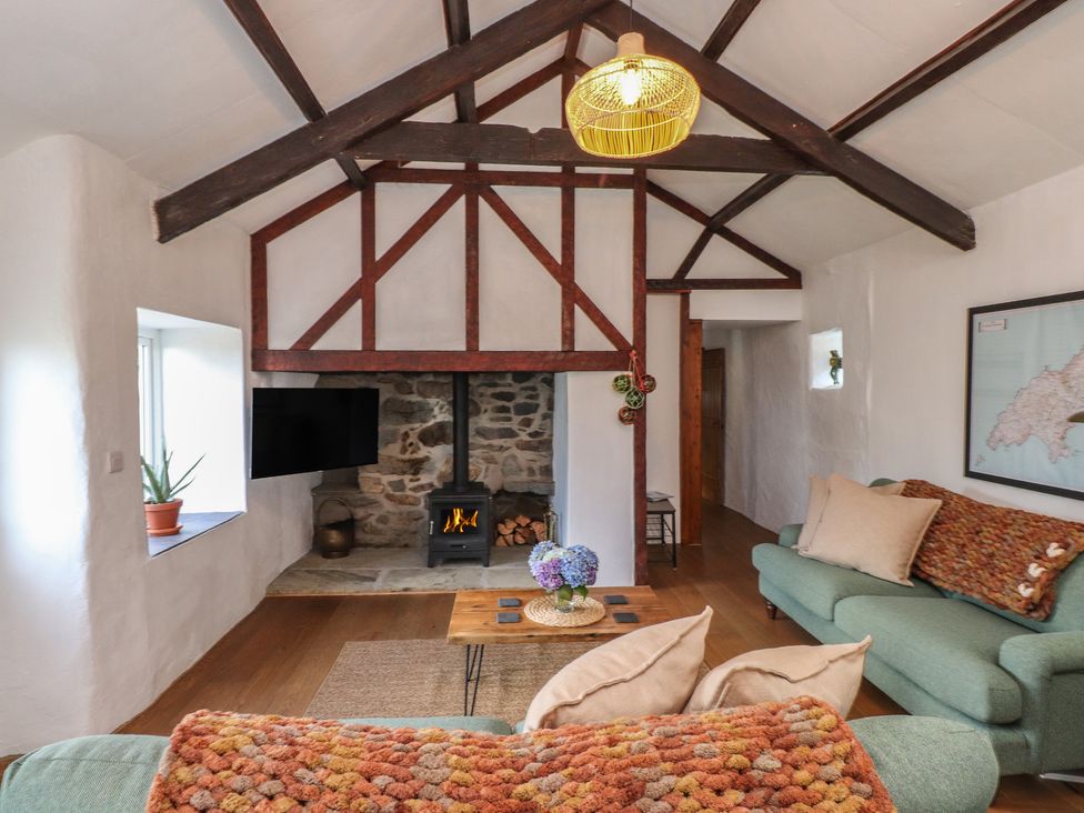 A living room with a sofa and stove at Garreg Fawr