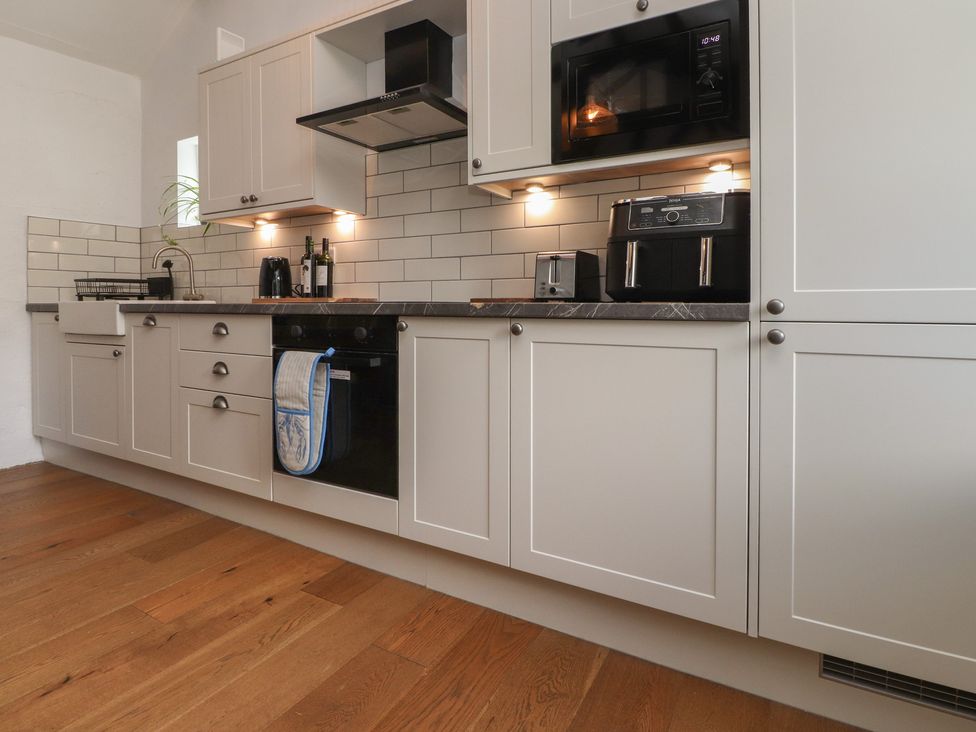 A kitchen with cabinets sink and appliances at Garreg Fawr