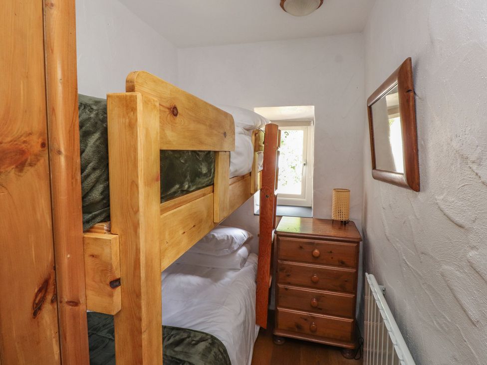 A bedroom with bunk bed and nightstand at Garreg Fawr
