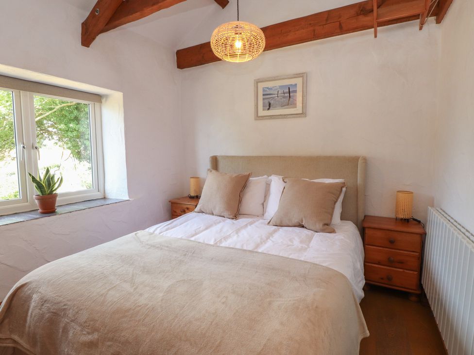 A bedroom with a bed and window at Garreg Fawr 