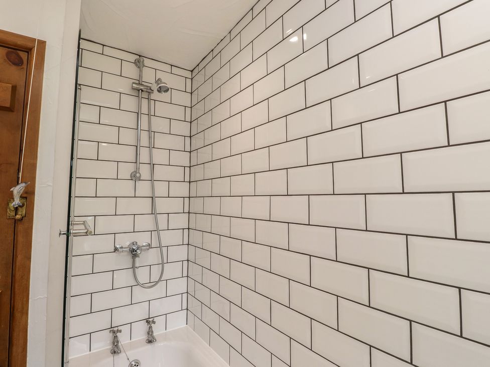A bathroom with a shower and bathtub at Garreg Fawr