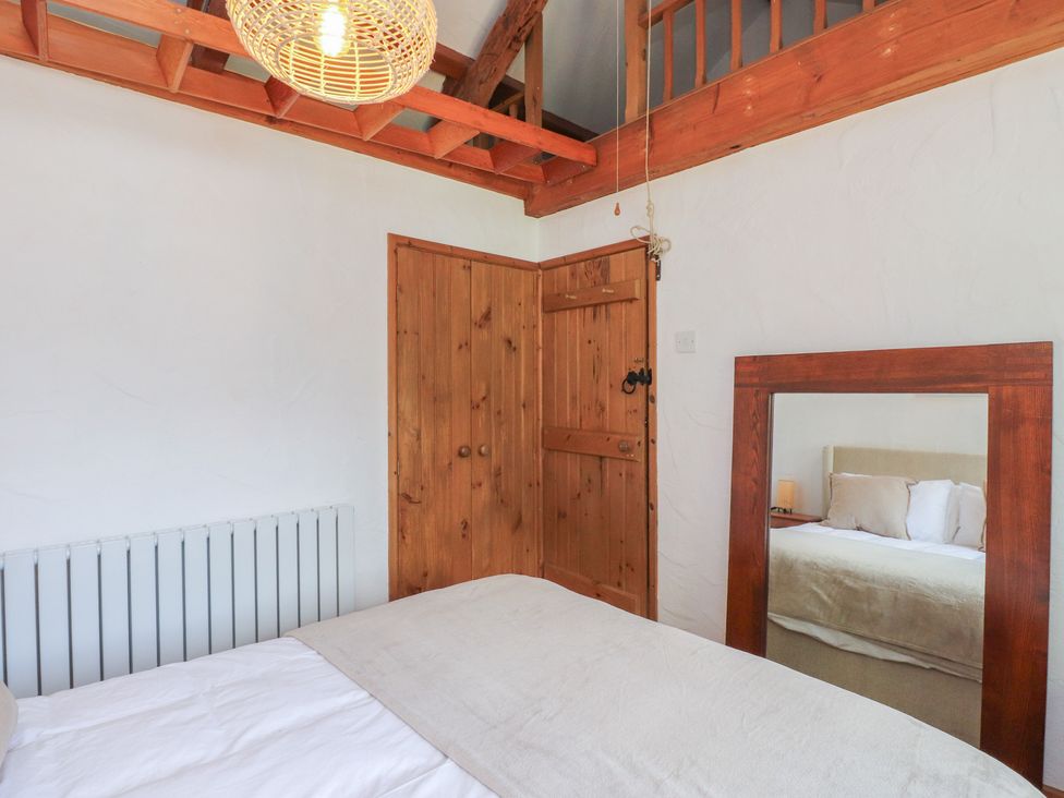 A bedroom with a bed and wooden furniture at Garreg Fawr