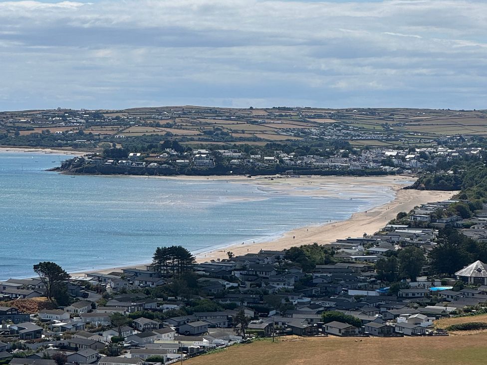 A view of a beach with houses and land at Garreg Fawr in Llanbedrog