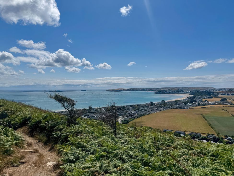 A coastal view from a hill overlooking water and fields at Garreg Fawr in Llanbedrog