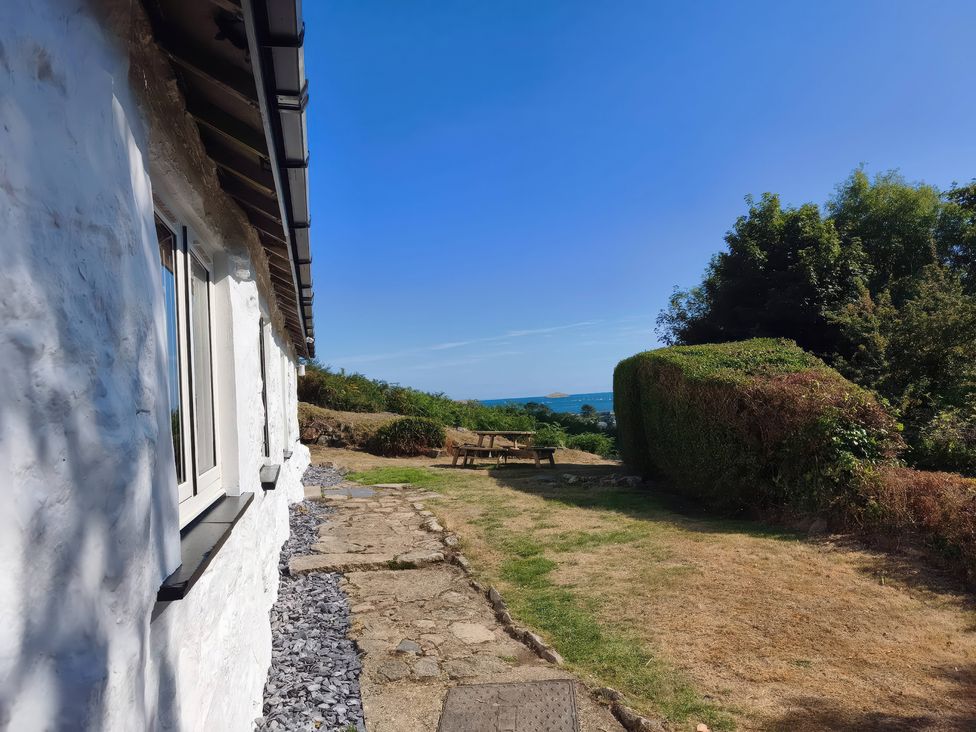 An outdoor area with a stone path and seating at Garreg Fawr in Llanbedrog