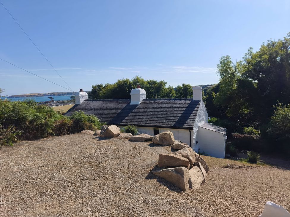 A house with a chimney and rocks at Garreg Fawr in Llanbedrog