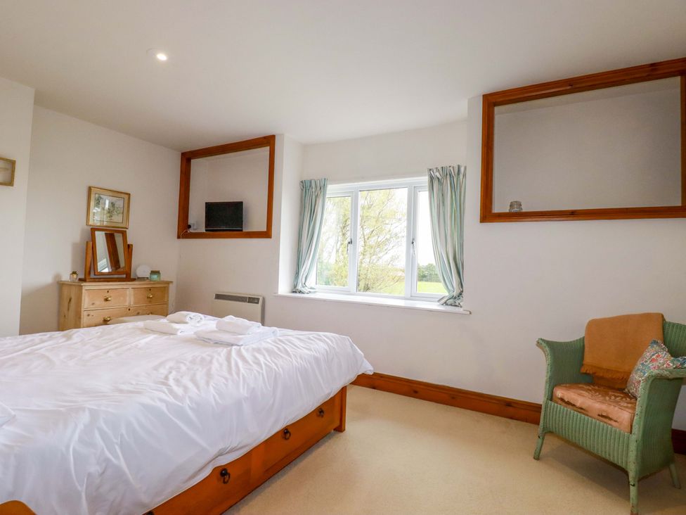 A bedroom with a bed and a dresser at Rosewin Farmhouse near St Minver