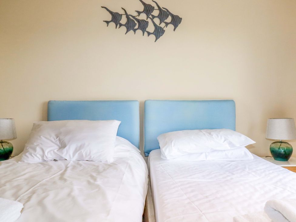 A bedroom with two single beds and a lamp at Rosewin Farmhouse near St Minver
