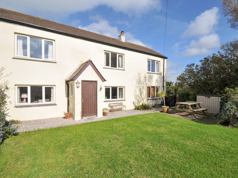 A house with a garden and seating area at Rosewin Farmhouse near St Minver