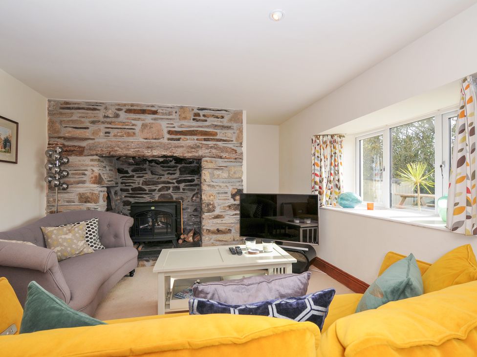 A living room with a sofa and fireplace at Rosewin Farmhouse near St Minver