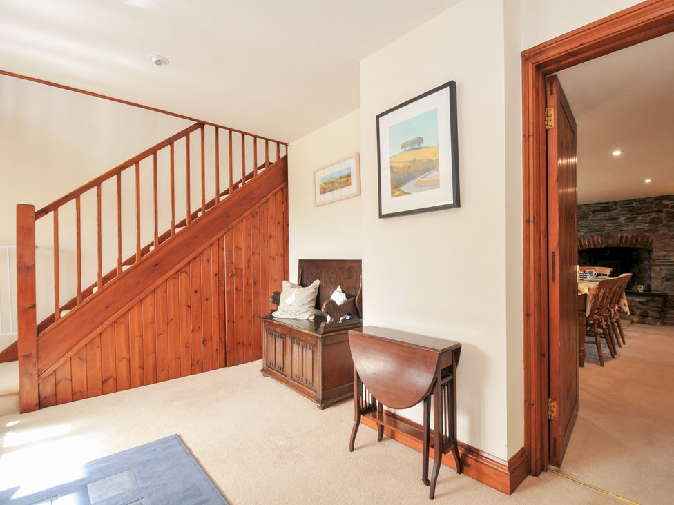 A hallway with a staircase and decorative furniture at Rosewin Farmhouse near St Minver