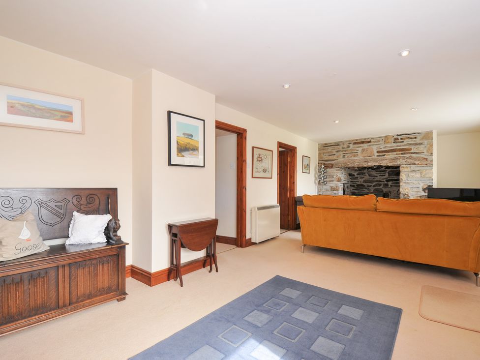 A living room with a sofa and fireplace at Rosewin Farmhouse near St Minver