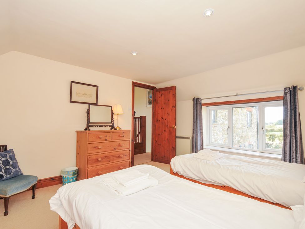 A bedroom with two beds and a dressing table at Rosewin Farmhouse near St Minver