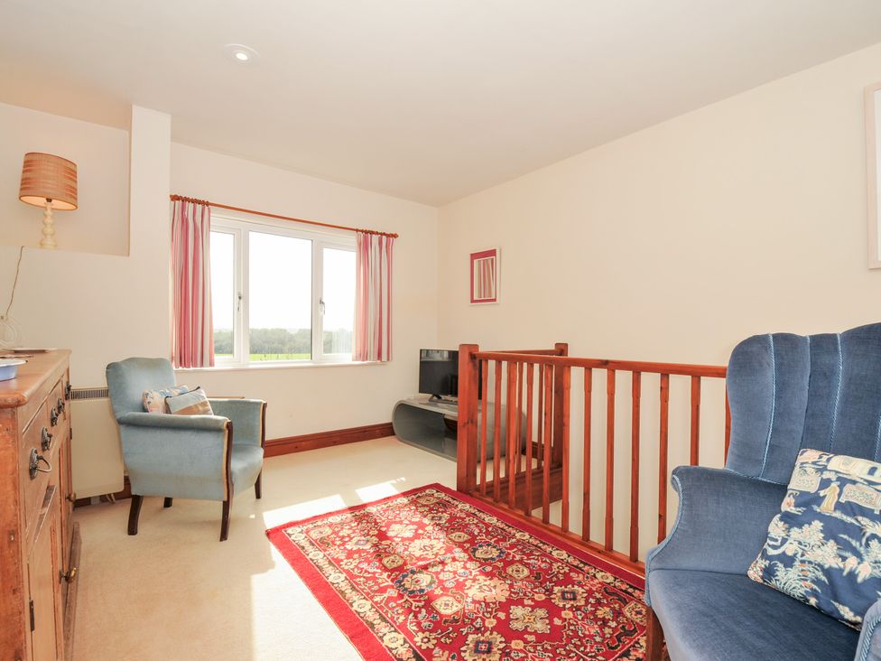 A living room with sofa and television at Rosewin Farmhouse near St Minver