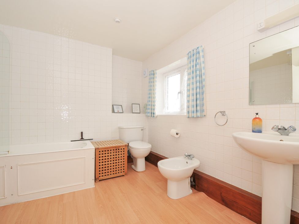 A bathroom with a bathtub, toilet, sink, and bidet at Rosewin Farmhouse near St Minver
