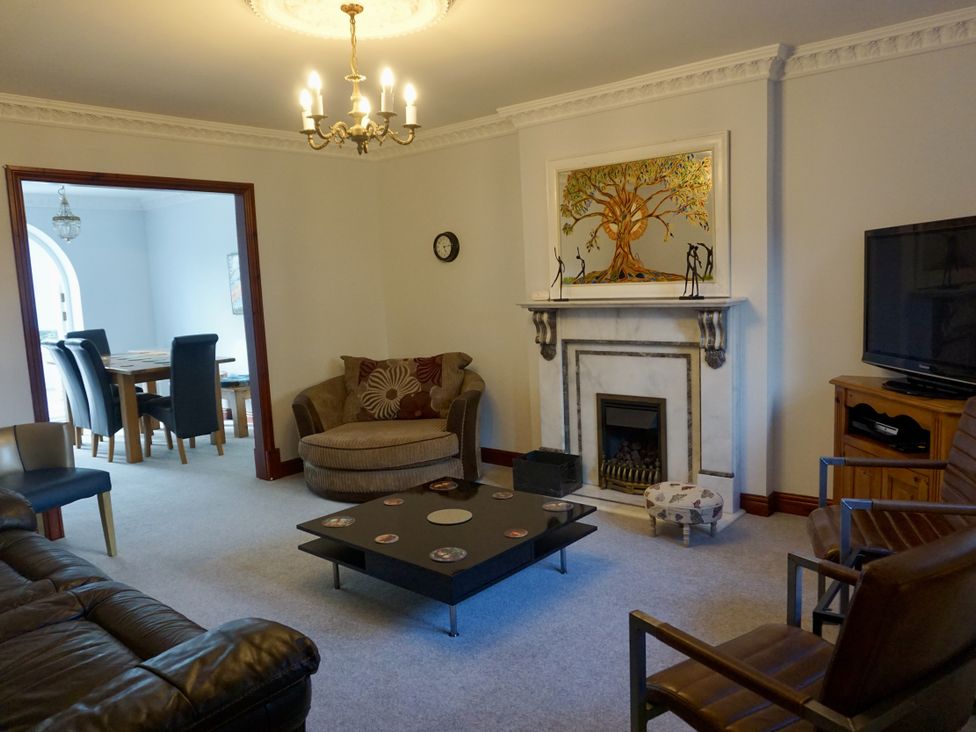 A living room with a sofa, coffee table, and fireplace at The Peak View Holmfirth