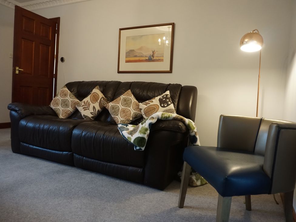 A living room with a sofa, cushions, and a chair at The Peak View Holmfirth