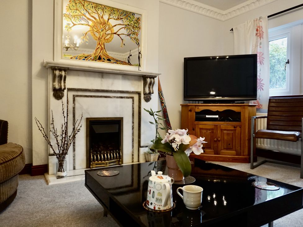 A living room with a fireplace and television at The Peak View Holmfirth
