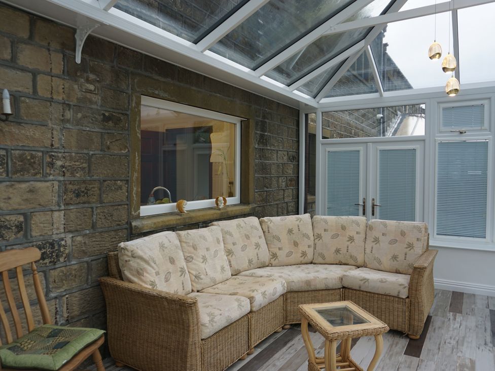 A conservatory with a seating area and table at The Peak View Holmfirth