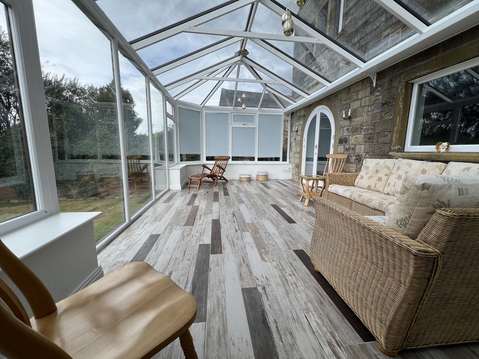 A conservatory with seating and table at The Peak View Holmfirth