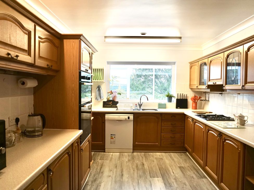 A kitchen with wooden cabinets and appliances at The Peak View Holmfirth