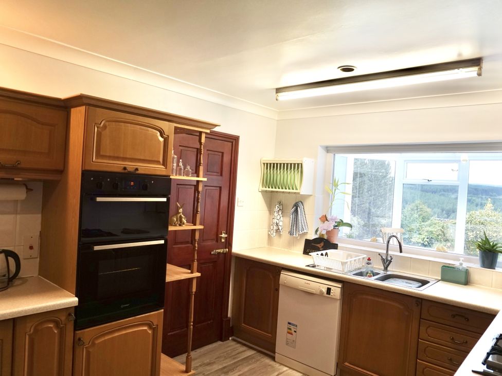 A kitchen with cabinets, oven, sink, and window at The Peak View Holmfirth