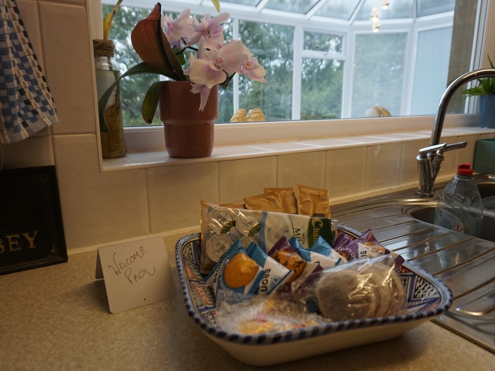 A kitchen with snacks and an orchid plant at The Peak View Holmfirth
