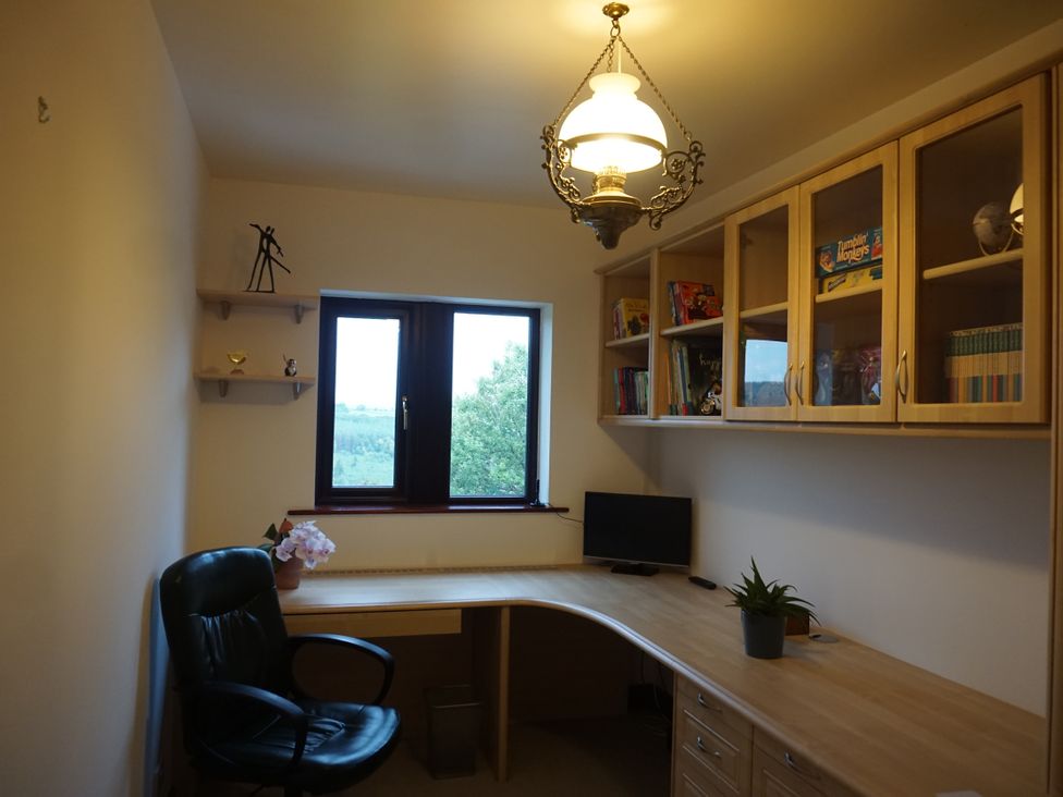 An office with a desk, chair, and shelves at The Peak View Holmfirth