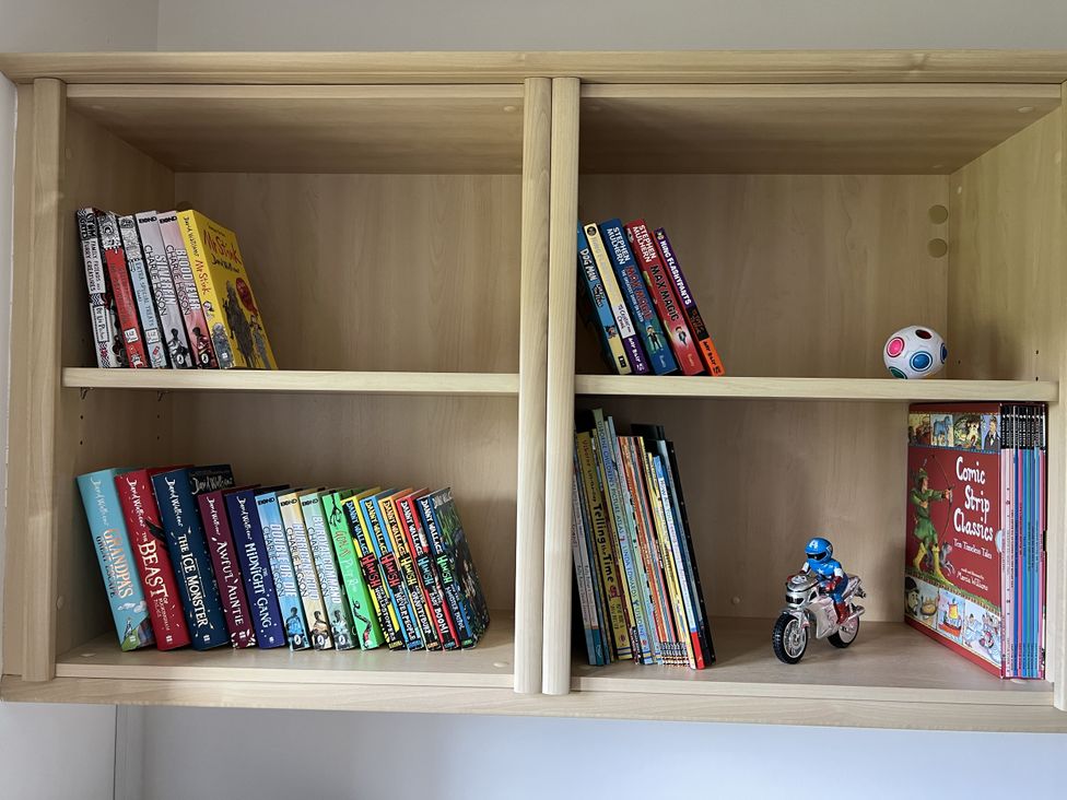 A bookshelf with various books and toys at The Peak View Holmfirth