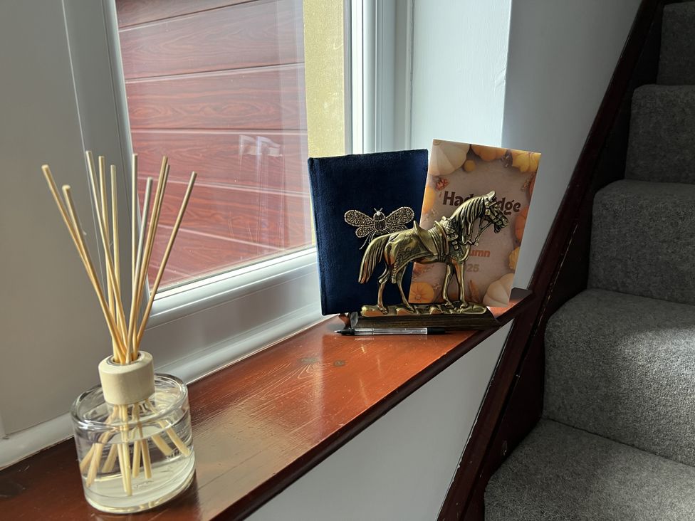 A window sill with a reed diffuser and a decorative horse figurine at The Peak View Holmfirth